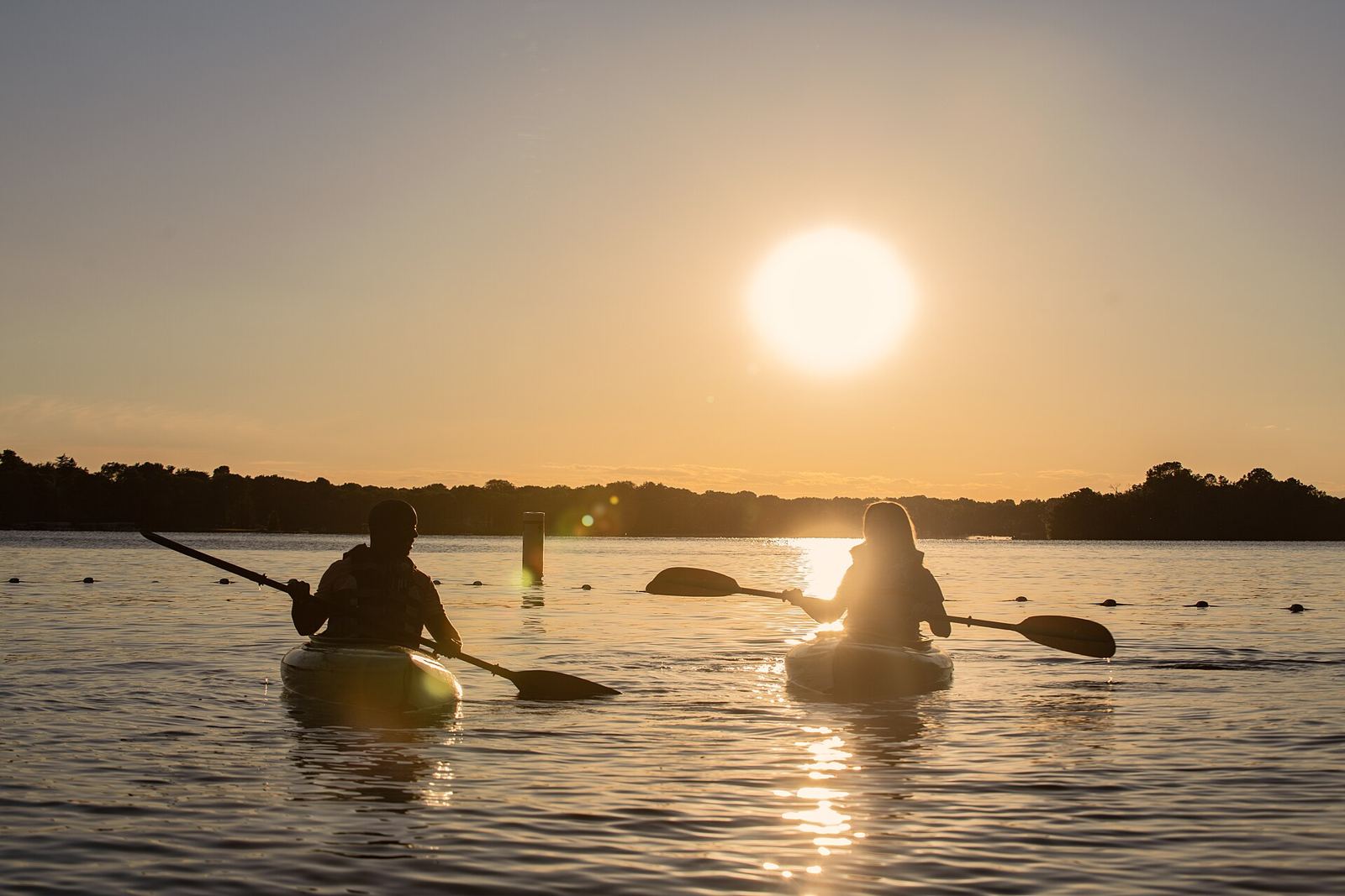 Kayakers paddling into the sunset on Nagawicka Lake., Delafield, WI